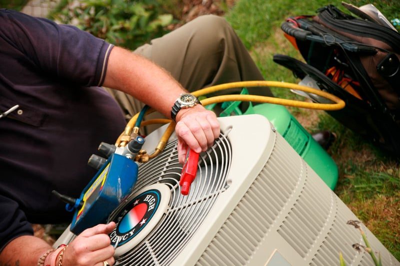 Guardian technician servicing an outdoor air conditioning condenser