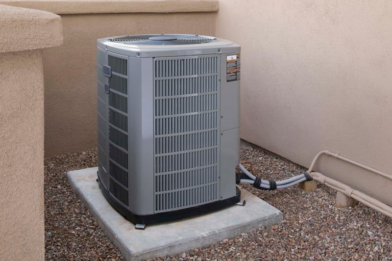 Outdoor HVAC condenser unit installed beside a home